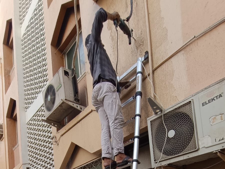 Our technician working on outdoor AC units on a building